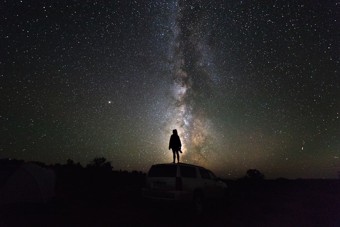 Silhouette Standing Under Vibrant Milky Way Galaxy