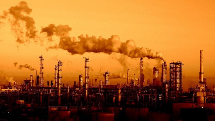 Industrial factory with smoke stacks at sunset