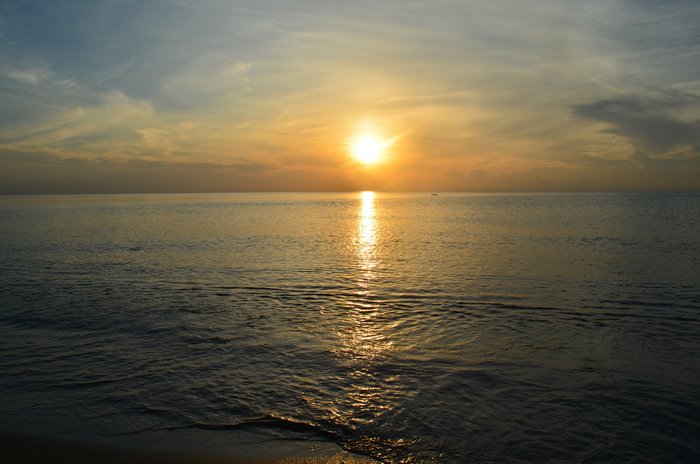 Sunset over the ocean with sun rays