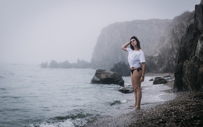 Woman in Bikini Standing by Foggy Ocean Cliff
