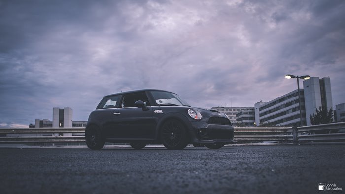 Black Mini JCW parked under cloudy sky