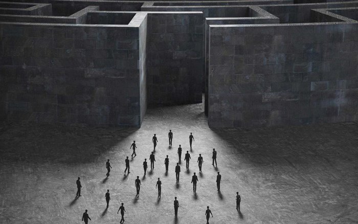 People entering a dark stone labyrinth