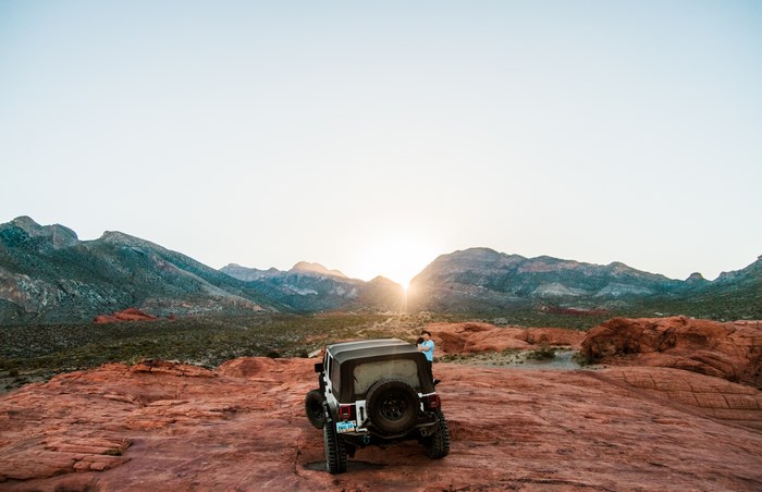 Jeep in a desert landscape at sunset