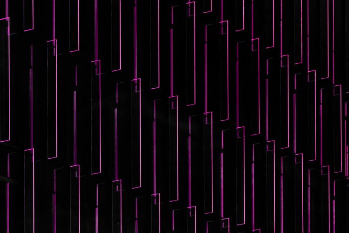 Abstract pattern of pink neon lines on black background