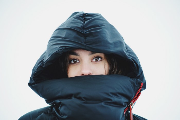 Young woman bundled in a dark hooded jacket