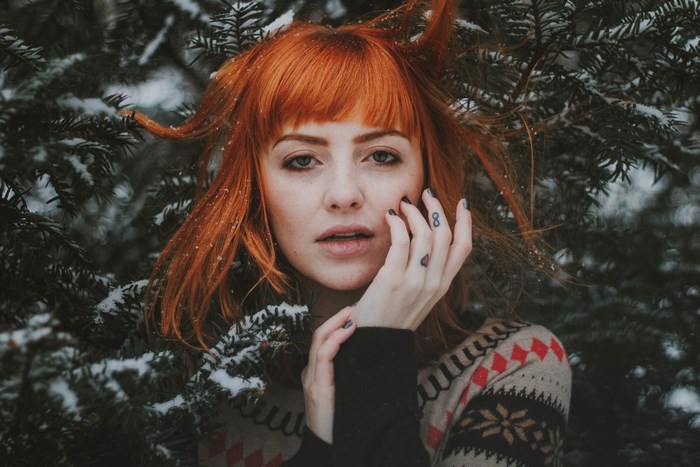 Woman with red hair in a snowy forest
