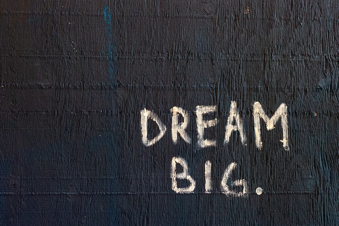 Dream Big. White text on dark textured surface