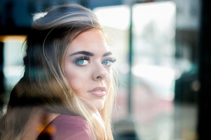 Woman with blue eyes looking through a window