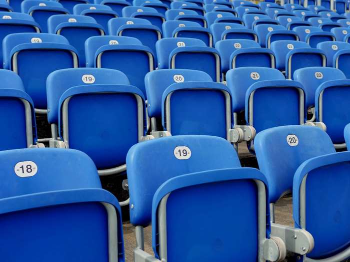 Rows of empty blue stadium seats with numbers