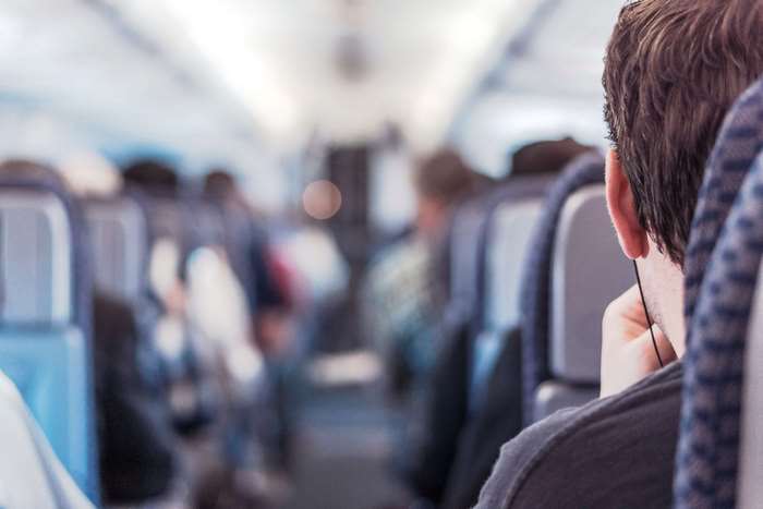 Man wearing headphones on an airplane