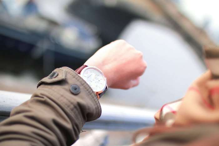 Person checking wristwatch on their arm