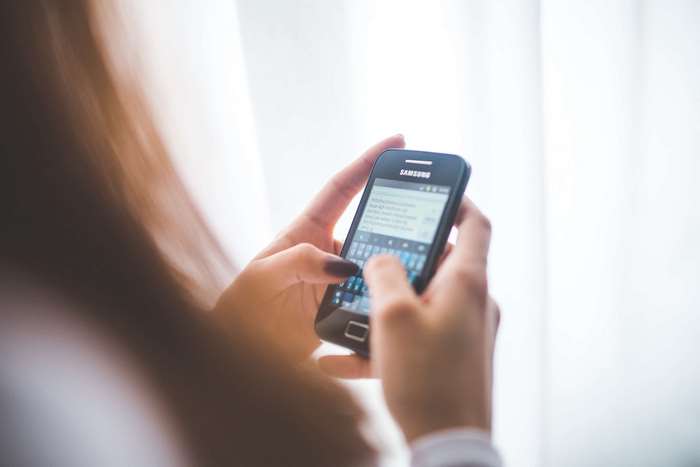 Woman typing on a Samsung smartphone
