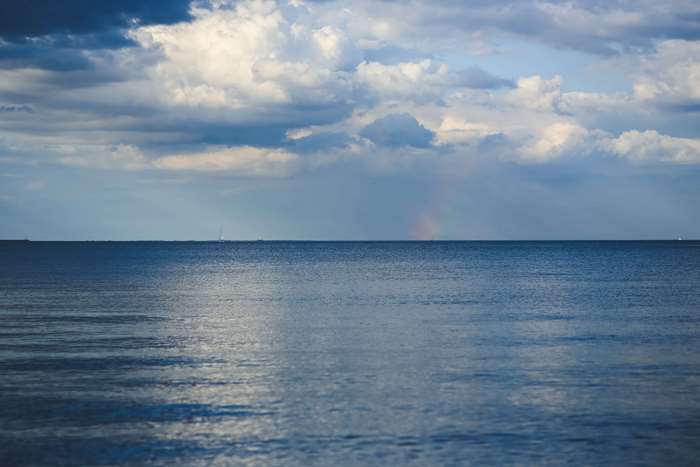 Ocean horizon with clouds and rainbow