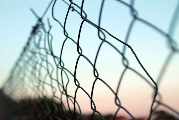 Close-up of a damaged chain-link fence