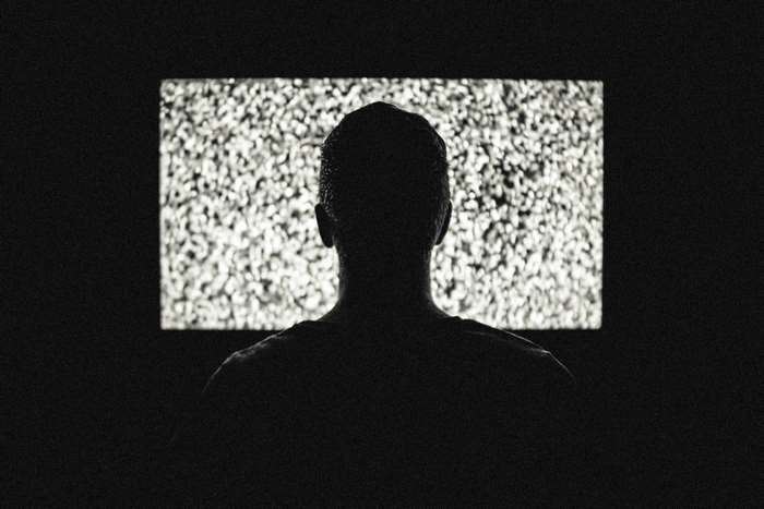Silhouette of a person watching television static
