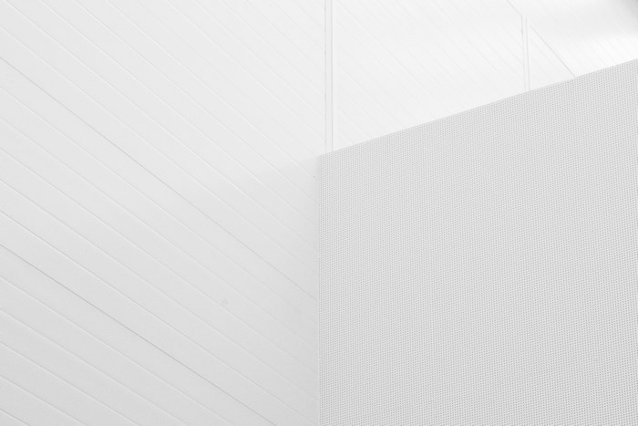 Modern white interior with diagonal lines and perforated panel