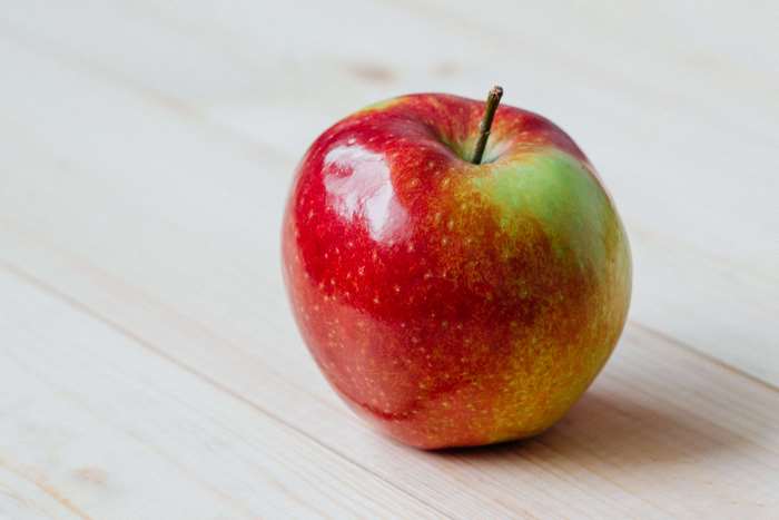 Red and green apple on a wooden surface
