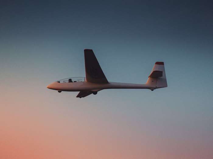 Glider flying in the sky at sunset