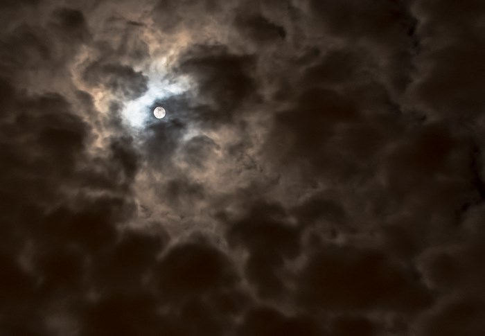 Full Moon Shining Through Stormy Clouds