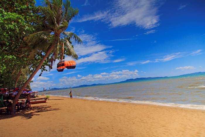 Parasail hanging from palm tree on Pattaya beach 4K