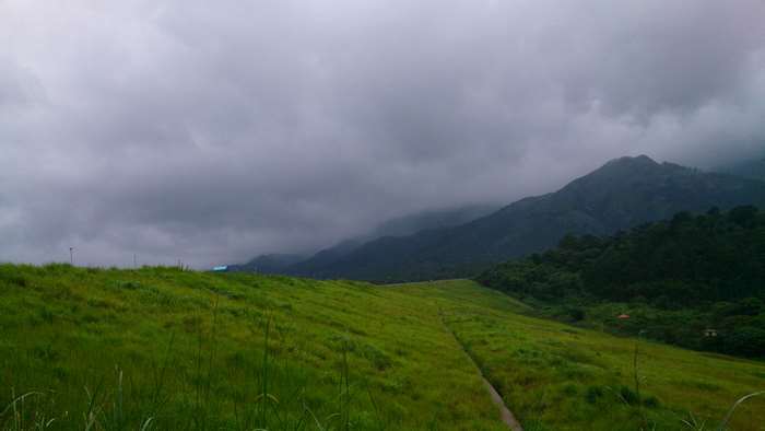 Green hills and mountains under cloudy sky