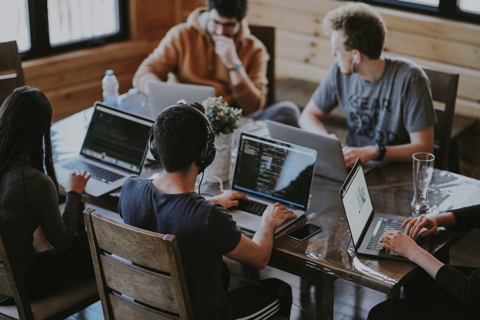 Team of developers working on laptops at a table