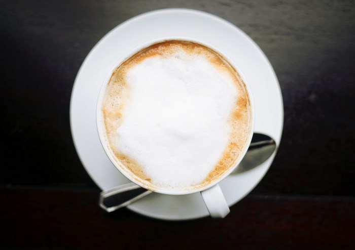 Top down view of a latte with foam on a saucer