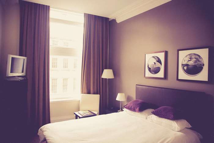 Bedroom with bed, curtains, and television