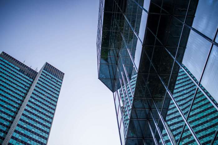 Modern glass skyscrapers reflecting the sky