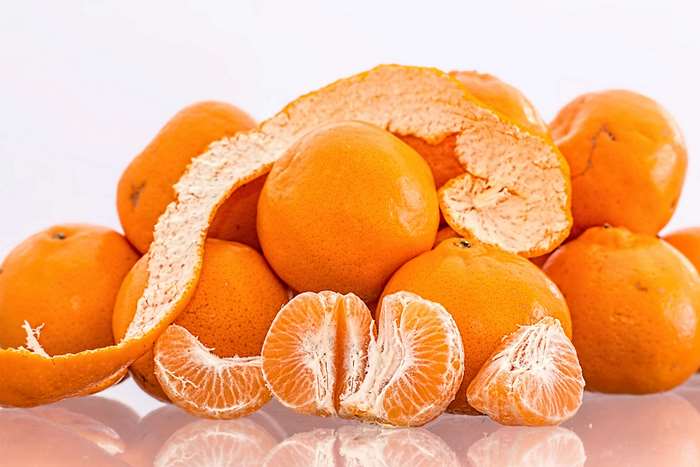 Pile of peeled and whole tangerines