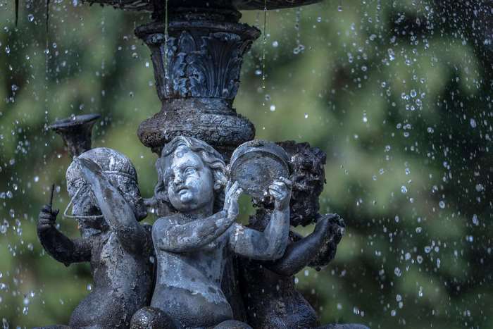 Cherub statues in a garden fountain with falling water