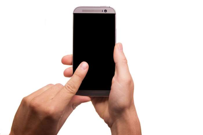 Hands holding a smartphone with a black screen