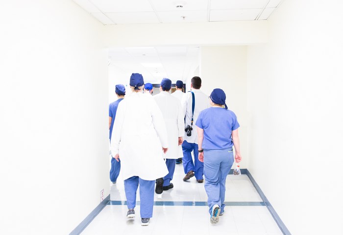 Medical professionals walking down a hospital hallway