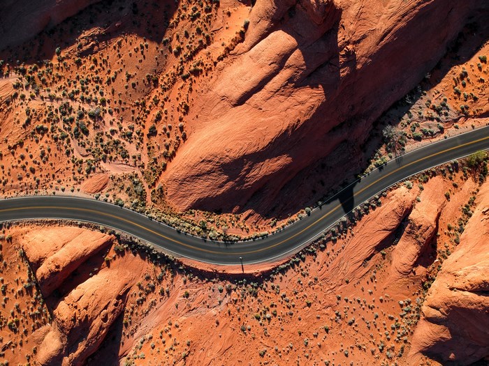 Aerial view of a winding road through red rock desert