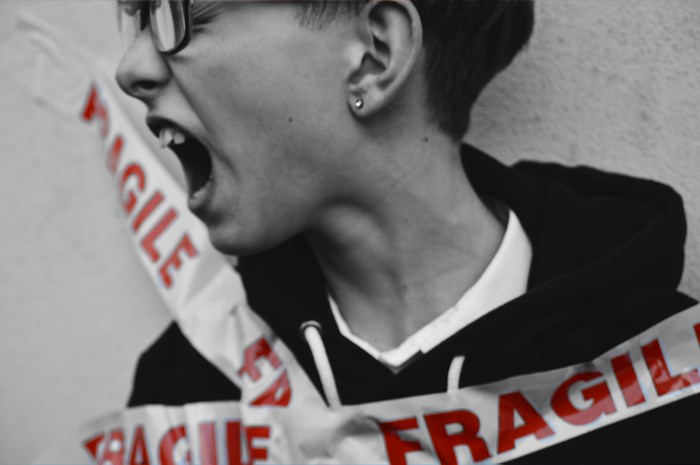 Person screaming, wrapped in fragile tape