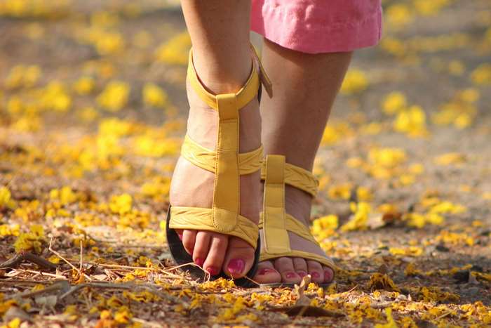 Woman wearing yellow sandals and pink pants