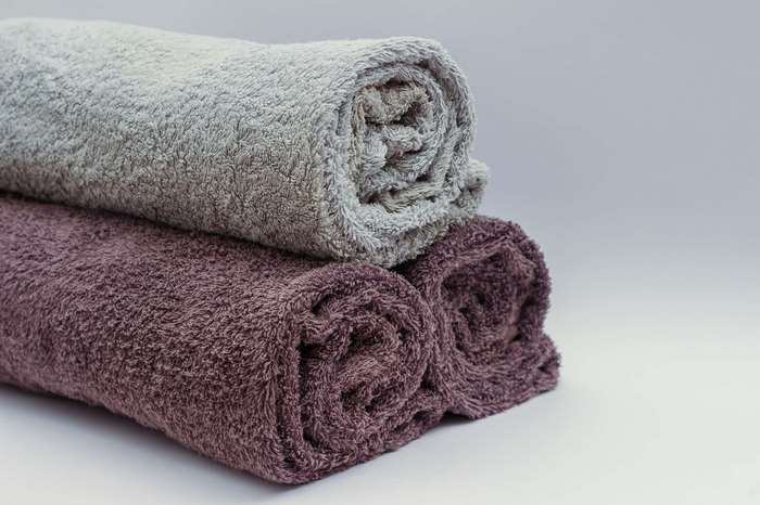 Rolled bath towels in grey and purple