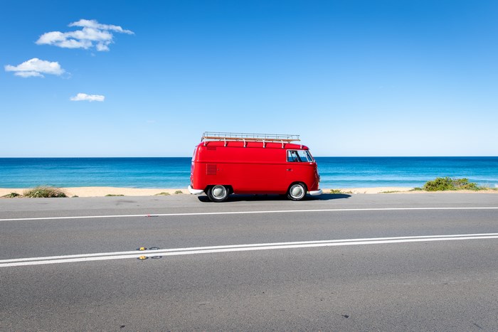 Red vintage van parked by the ocean