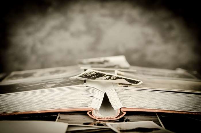 Old photo album with scattered photographs