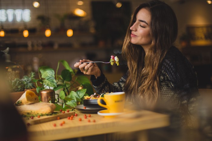 Woman enjoying pasta and coffee at a restaurant