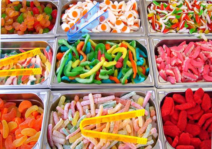 Assortment of colorful gummy candies in metal trays