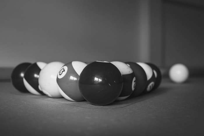 Billiard balls racked on a billiard table, black and white
