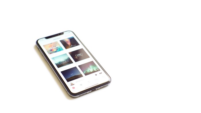 iPhone X displaying music app with album art