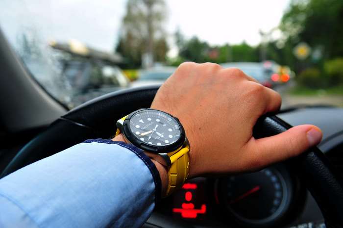 Man wearing Nautica watch driving car