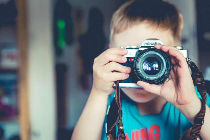 Boy holding a Minolta camera