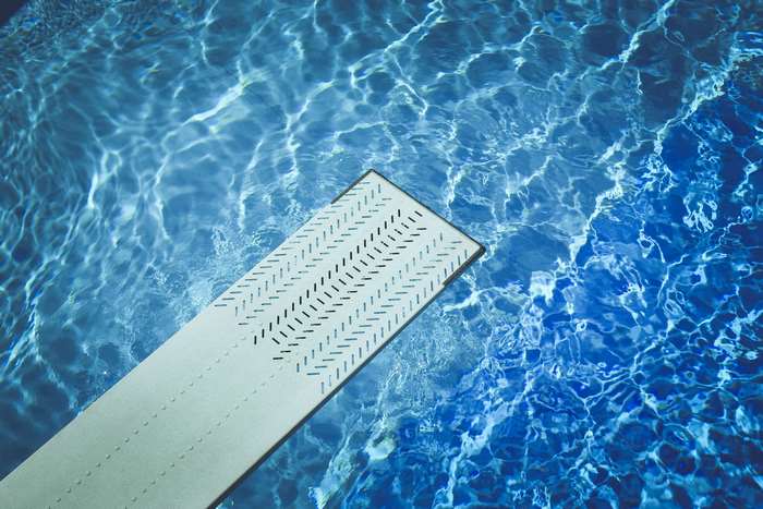 Diving board over a blue swimming pool
