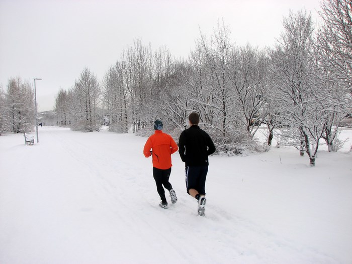 Two people running in the snow