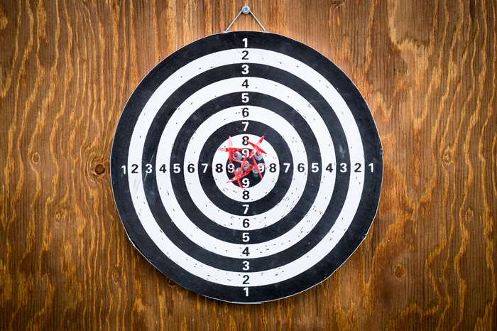 Dartboard with darts on a wooden wall