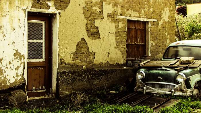 Abandoned car in front of an old house in Psimolofou, Cyprus