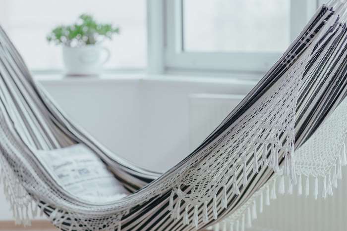 Hammock with pillow and potted plant near window